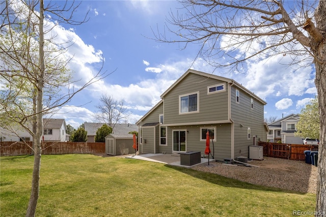 back of property featuring a patio, a storage unit, a lawn, a fenced backyard, and an outbuilding