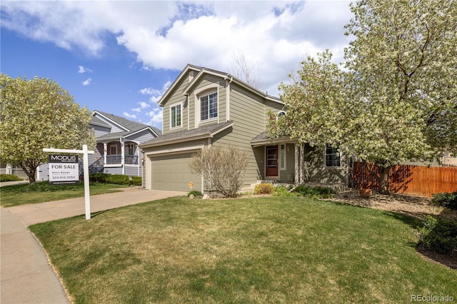 view of front of home featuring driveway, a garage, fence, and a front yard