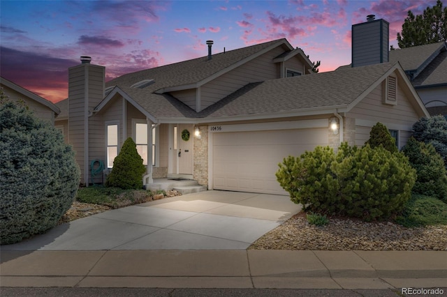 10436 W 84th Pl, Arvada, CO 80005 - view of front of home featuring a garage, a shingled roof, a chimney, and concrete driveway
