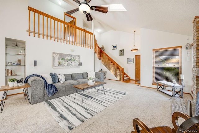 10436 W 84th Pl, Arvada, CO 80005 - carpeted living area with baseboards, a skylight, ceiling fan, stairway, and high vaulted ceiling