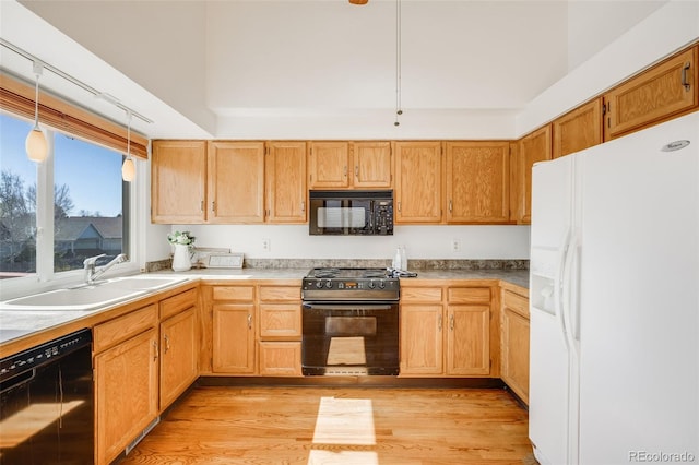 10436 W 84th Pl, Arvada, CO 80005 - kitchen with light wood finished floors, pendant lighting, a sink, and black appliances