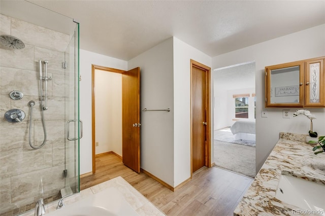 10436 W 84th Pl, Arvada, CO 80005 - full bathroom with a stall shower, baseboards, wood finished floors, vanity, and connected bathroom