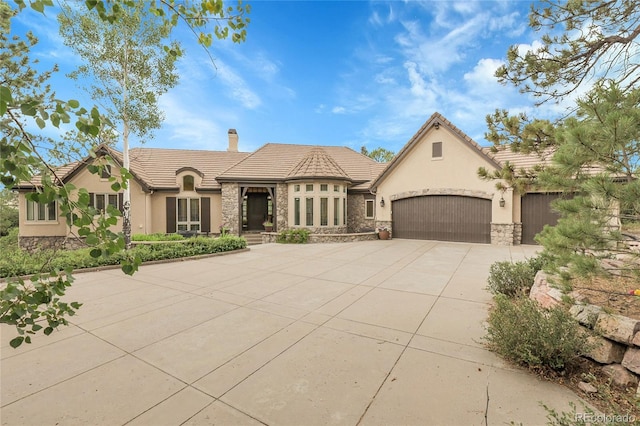 917 Dakota Dr, Castle Rock, CO 80108 - view of front of property with stone siding, driveway, stucco siding, a chimney, and a garage