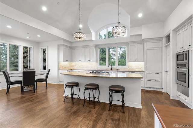 917 Dakota Dr, Castle Rock, CO 80108 - kitchen with appliances with stainless steel finishes, lofted ceiling, plenty of natural light, a kitchen island, and decorative backsplash
