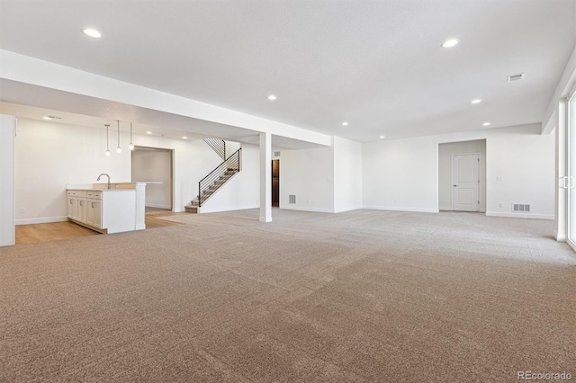 basement featuring sink and light carpet