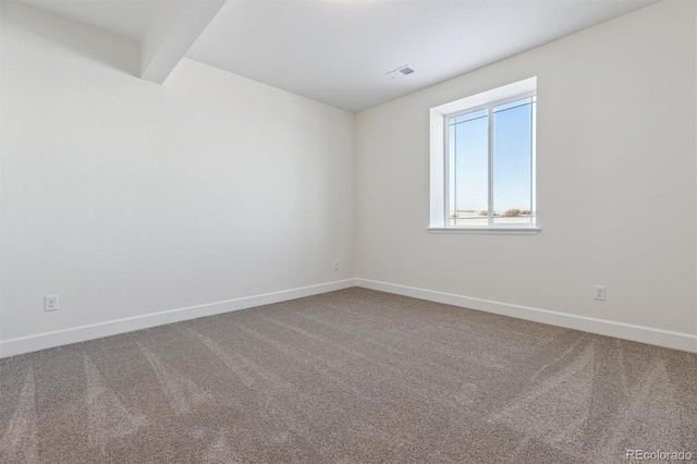 carpeted empty room featuring beamed ceiling