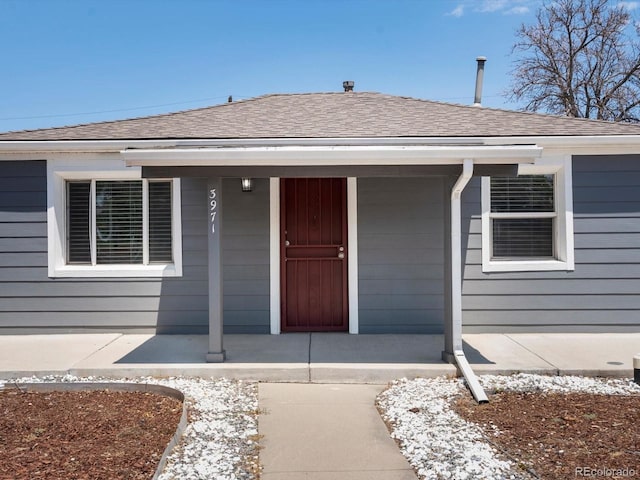 3971 W Kentucky Ave, Denver, CO 80219 - property entrance featuring a porch and a shingled roof