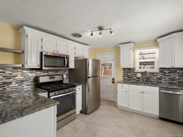 3971 W Kentucky Ave, Denver, CO 80219 - kitchen featuring appliances with stainless steel finishes, tasteful backsplash, and white cabinetry