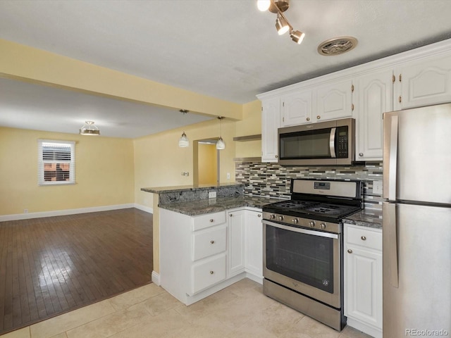 3971 W Kentucky Ave, Denver, CO 80219 - kitchen featuring appliances with stainless steel finishes, a peninsula, white cabinets, backsplash, and dark stone countertops
