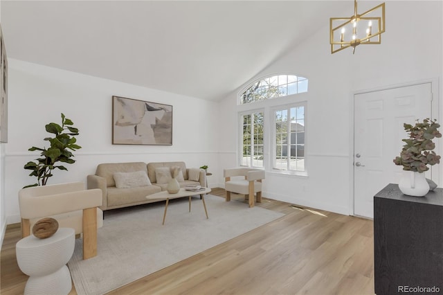 living area with light wood-style floors, a chandelier, and high vaulted ceiling