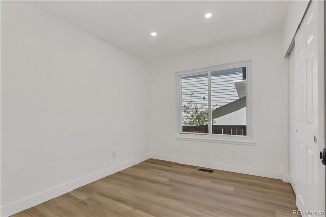 unfurnished room with baseboards, light wood-style flooring, and recessed lighting