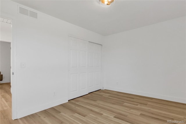 empty room featuring light wood-type flooring and baseboards