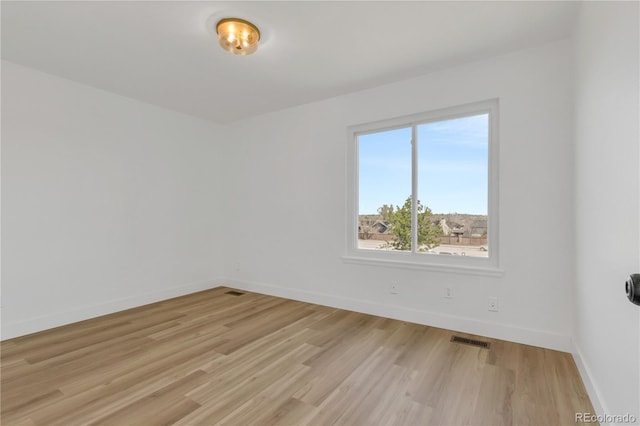 unfurnished room featuring baseboards and light wood-style flooring