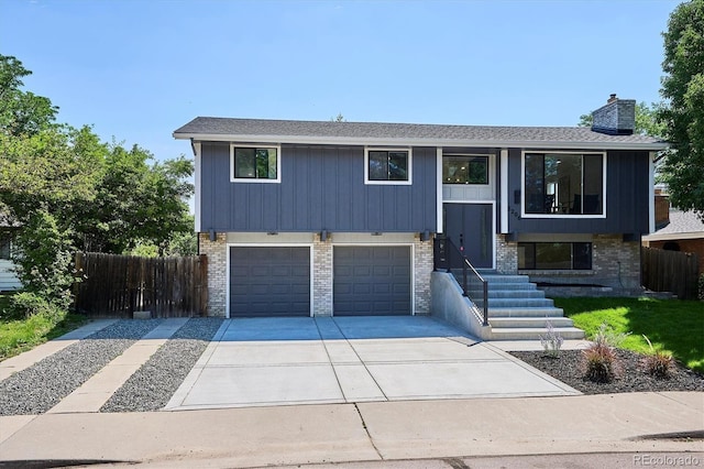 3206 S Pontiac St, Denver, CO 80224 - bi-level home featuring brick siding, driveway, an attached garage, and a chimney