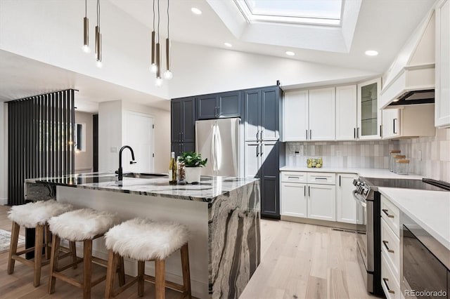 3206 S Pontiac St, Denver, CO 80224 - kitchen with stainless steel appliances, premium range hood, light wood-style floors, a skylight, and recessed lighting
