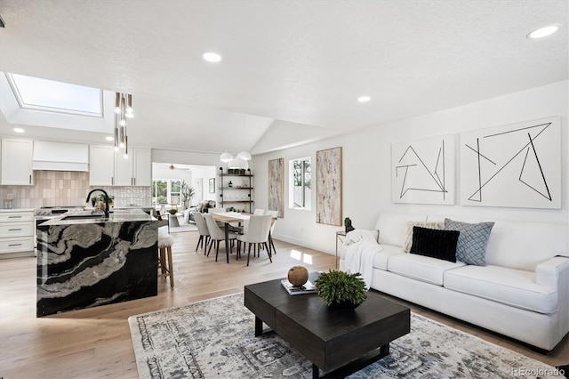 3206 S Pontiac St, Denver, CO 80224 - living room with light wood finished floors, recessed lighting, a skylight, and lofted ceiling