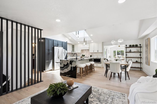 3206 S Pontiac St, Denver, CO 80224 - living room with light wood finished floors, recessed lighting, and a skylight
