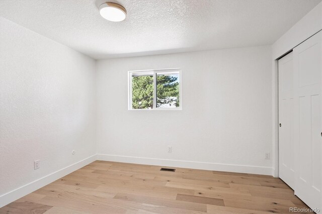 3206 S Pontiac St, Denver, CO 80224 - unfurnished bedroom featuring light wood-style flooring, a closet, and a textured ceiling