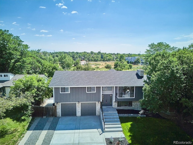 3206 S Pontiac St, Denver, CO 80224 - split foyer home featuring an attached garage, roof with shingles, concrete driveway, stone siding, and a chimney