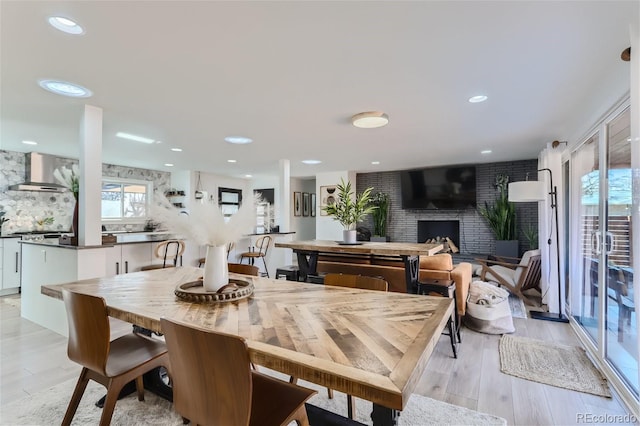 dining room featuring a fireplace and light wood-type flooring