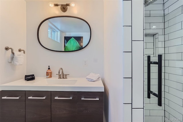 bathroom with tiled shower and vanity