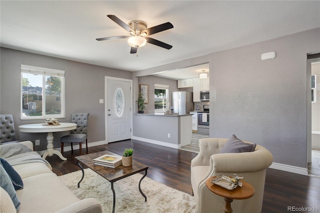 living room featuring ceiling fan and dark hardwood / wood-style floors