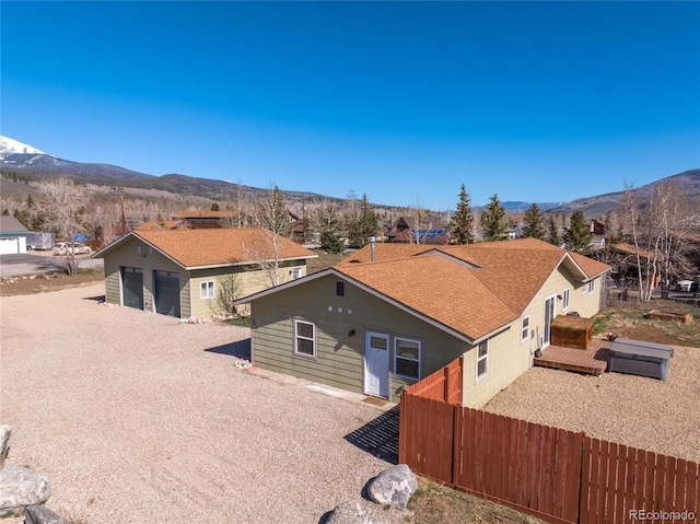 840 Mesa Dr, Silverthorne, CO 80498 - bungalow-style house with a garage, a deck with mountain view, fence, and a shingled roof