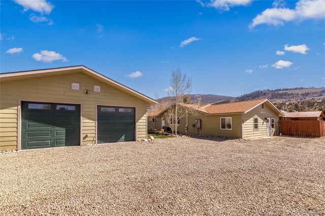 840 Mesa Dr, Silverthorne, CO 80498 - ranch-style house with gravel driveway, a garage, a mountain view, and fence