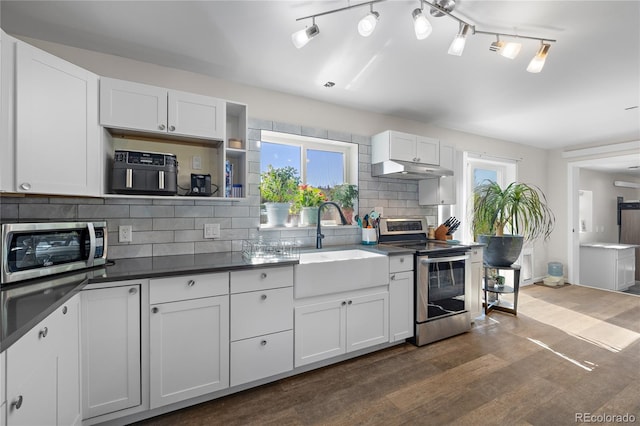 840 Mesa Dr, Silverthorne, CO 80498 - kitchen featuring stainless steel appliances, dark countertops, backsplash, dark wood finished floors, and under cabinet range hood