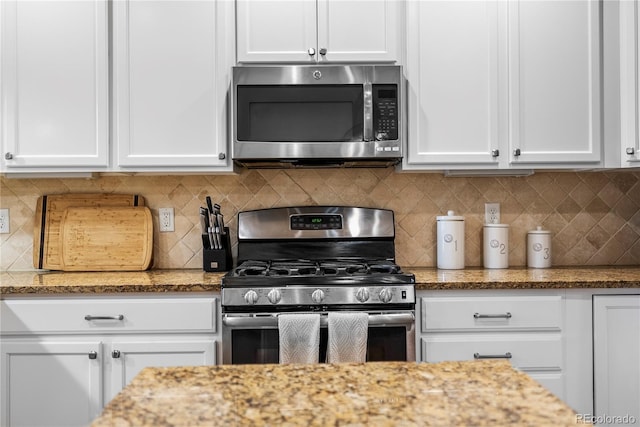 kitchen featuring appliances with stainless steel finishes, white cabinets, and decorative backsplash