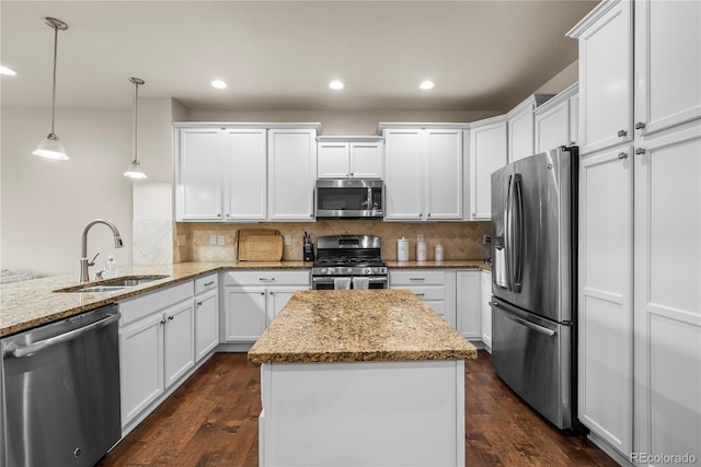 kitchen featuring stainless steel appliances, a sink, white cabinets, backsplash, and recessed lighting
