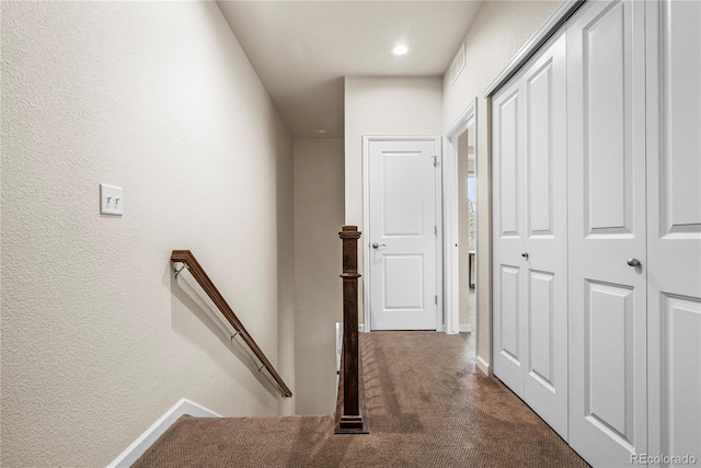 hallway featuring an upstairs landing, baseboards, carpet floors, a textured wall, and recessed lighting