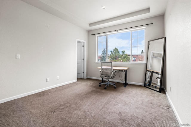 carpeted home office with baseboards and a tray ceiling
