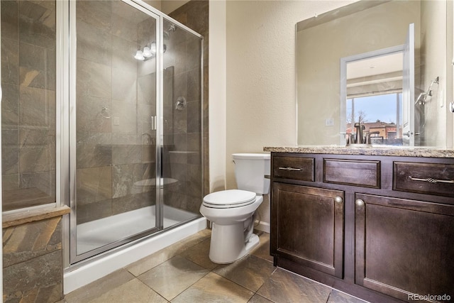 full bathroom with a shower stall, vanity, and toilet