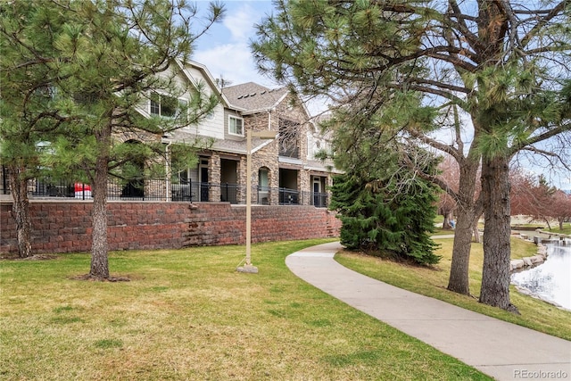 view of front of house featuring stone siding and a front yard