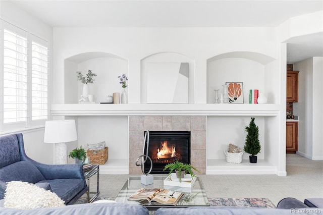 carpeted living area with a tile fireplace
