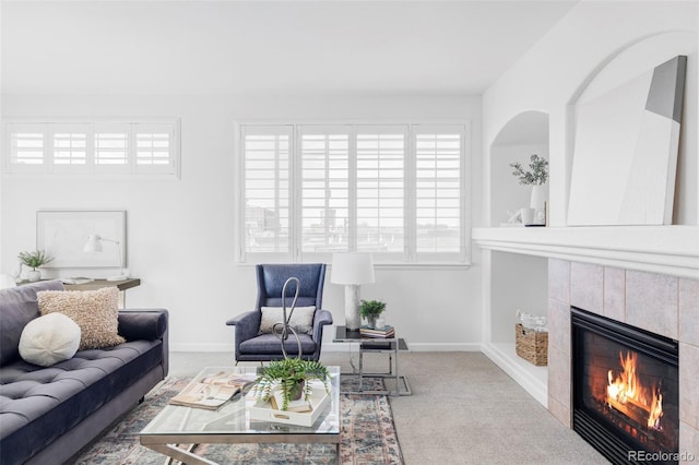 carpeted living area featuring baseboards and a fireplace