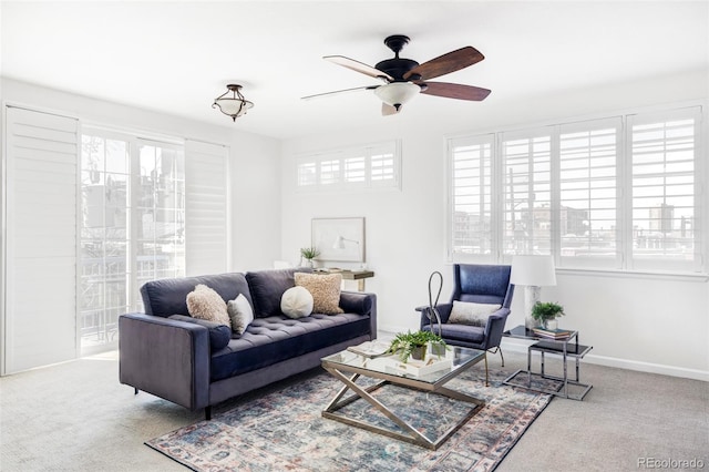 living area with ceiling fan, carpet floors, and baseboards