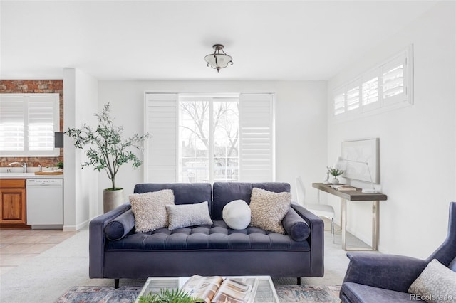 living room featuring baseboards, light carpet, and light tile patterned floors