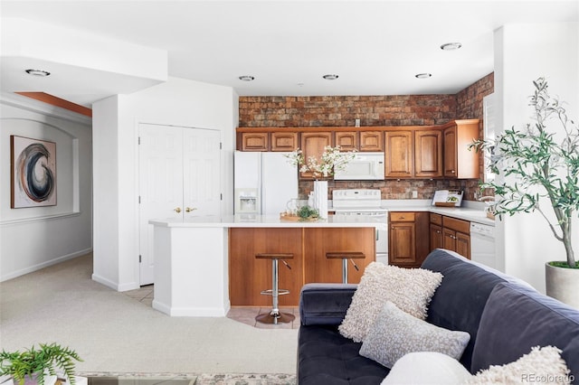 kitchen featuring light carpet, light countertops, white appliances, and a kitchen island