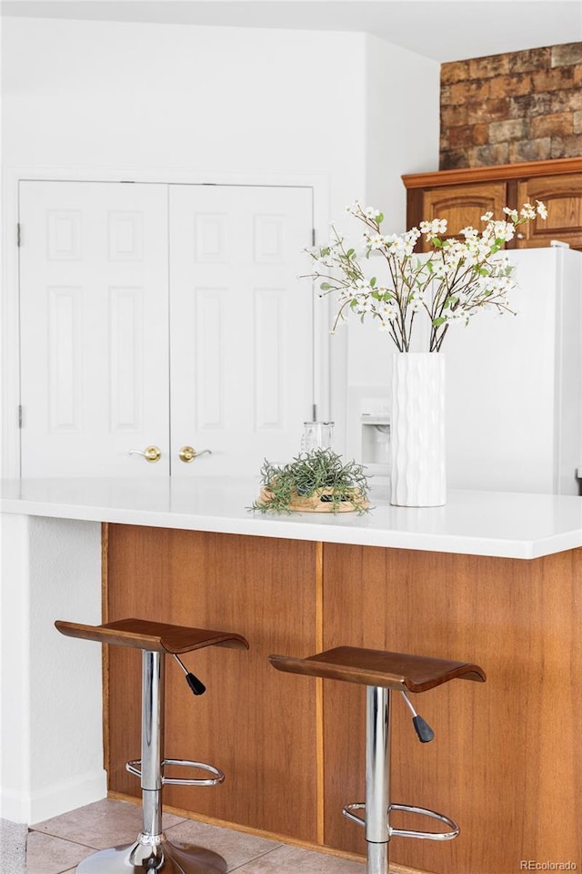 bar with tile patterned floors and baseboards