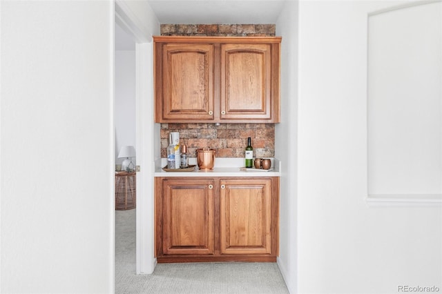 bar with a bar, light colored carpet, and decorative backsplash