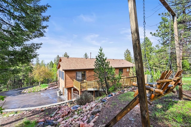 29825 Kennedy Gulch Rd, Conifer, CO 80433 - back of property with a deck, driveway, a shingled roof, an attached garage, and a patio