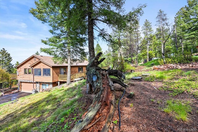 29825 Kennedy Gulch Rd, Conifer, CO 80433 - back of property with an attached garage, driveway, and a wooden deck