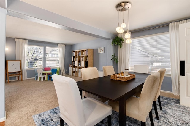 dining space featuring baseboards and carpet