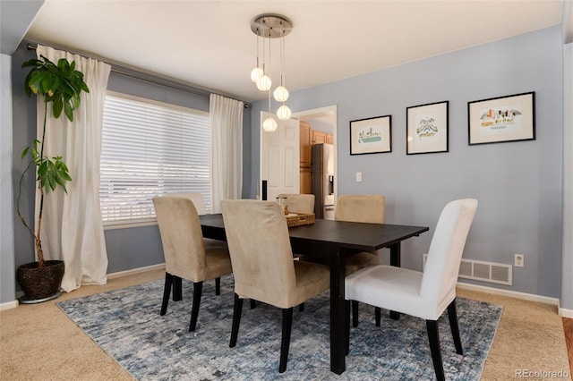 dining space with visible vents, light colored carpet, and baseboards