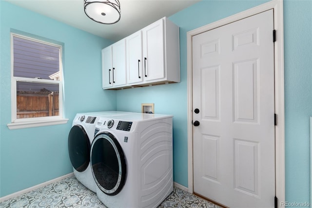 laundry area with light tile patterned flooring, cabinet space, baseboards, and washer and clothes dryer