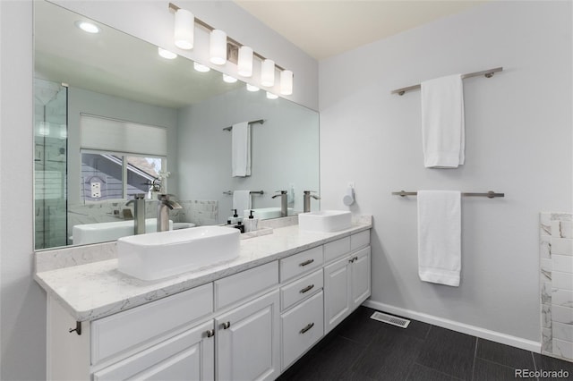 bathroom featuring a sink, visible vents, baseboards, and double vanity