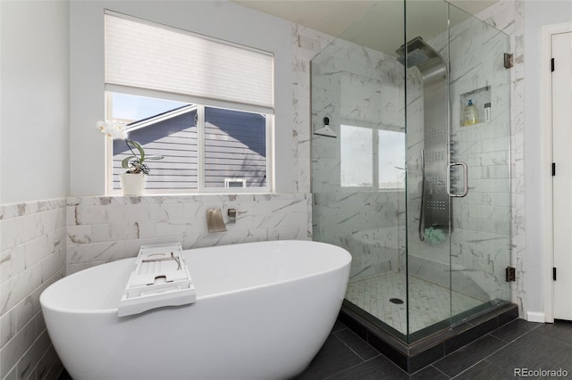 full bath featuring a wealth of natural light, a shower stall, and a freestanding tub