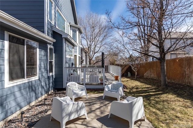 view of patio featuring grilling area, fence, and a wooden deck